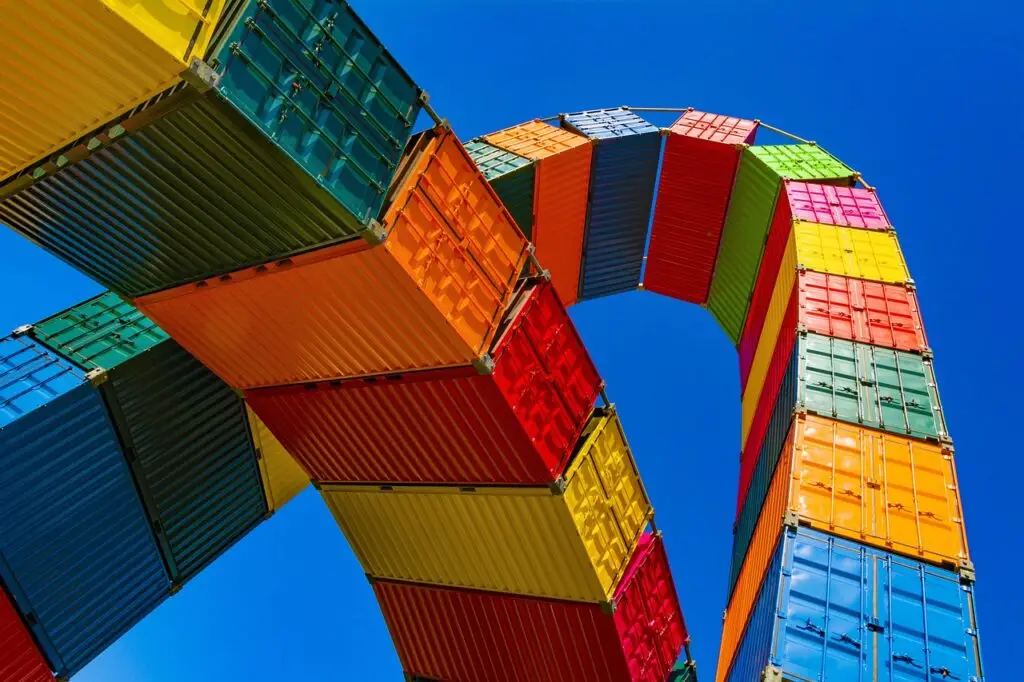 Multicolour shipping containers looping overhead with blue sky background